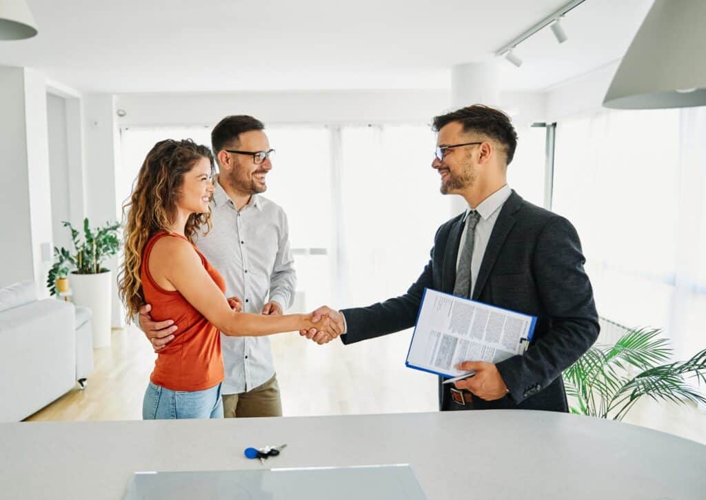 poignée de main entre professionnel de l'immobilier et un couple